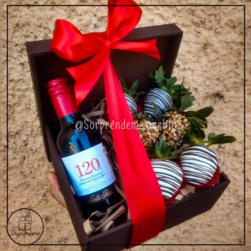 Caja de madera con botella de vino y fresas cubiertas con chocolate